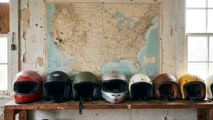 Various DOT-certified motorcycle helmets arranged on shelf with United States map background